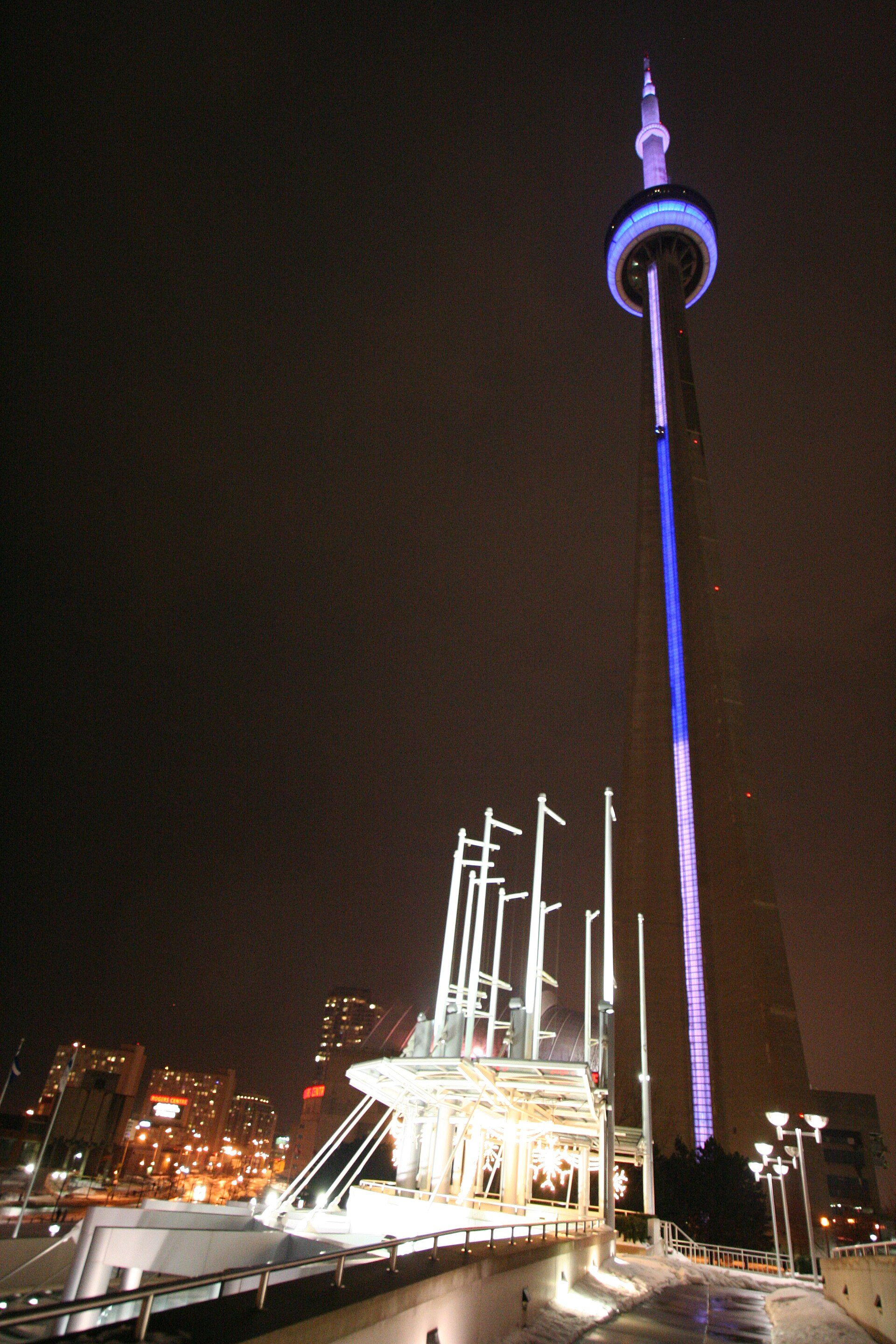 The tower lit at night above the Toronto skyline